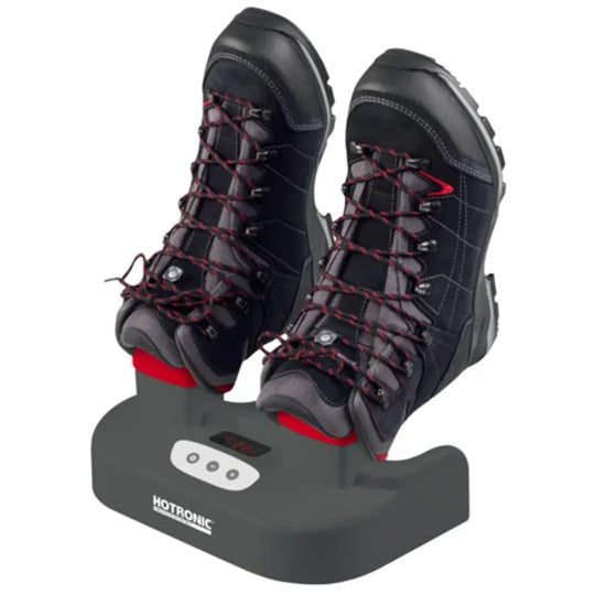 Pair of black and red hiking boots on a black boot dryer with Hotronic branding.