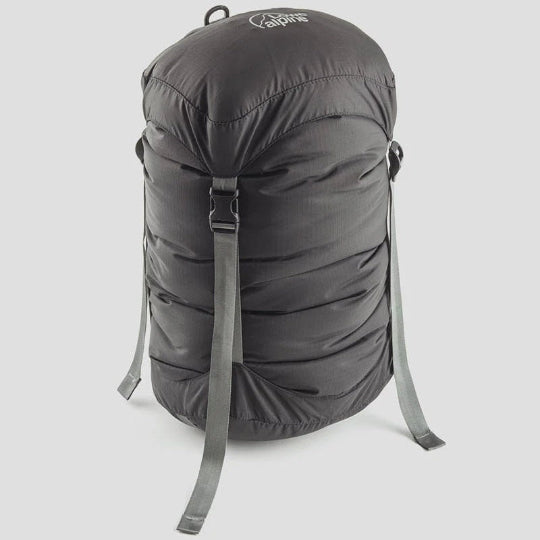 A black nylon compression sack with a roll-top closure and side release buckles, featuring a grey D-ring hang loop.