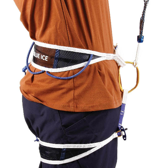 Person wearing a climbing harness with equipment on a white background