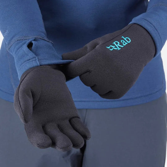 Person wearing black gloves with a visible brand logo, blue long-sleeve shirt, and gray pants.
