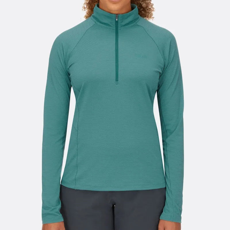 Woman wearing a teal long-sleeve athletic top with a quarter zip on a white background