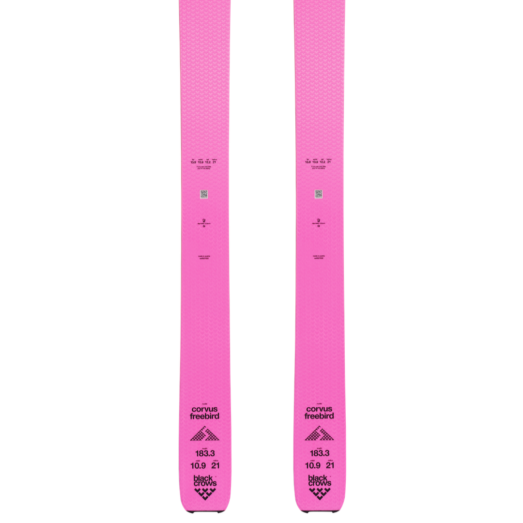 A pair of pink Corvus Freebird skis with bindings attached, showcasing the profile view of the skis.