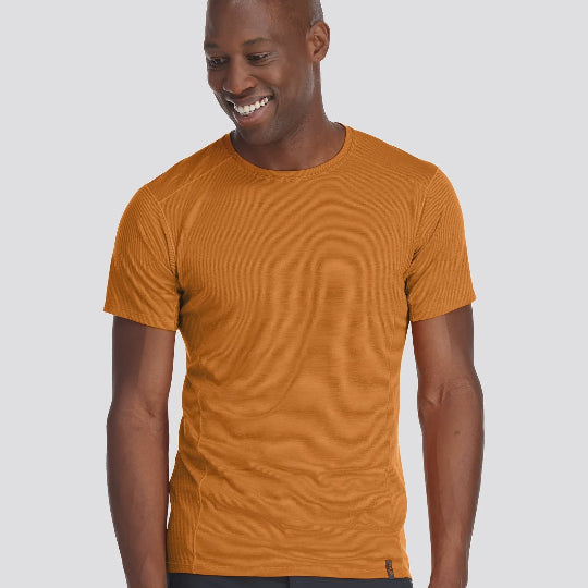 Man wearing a mustard yellow t-shirt on a light gray background