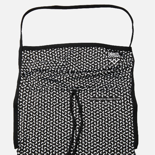 Black and white patterned neck gaiter with drawstring on a light gray background