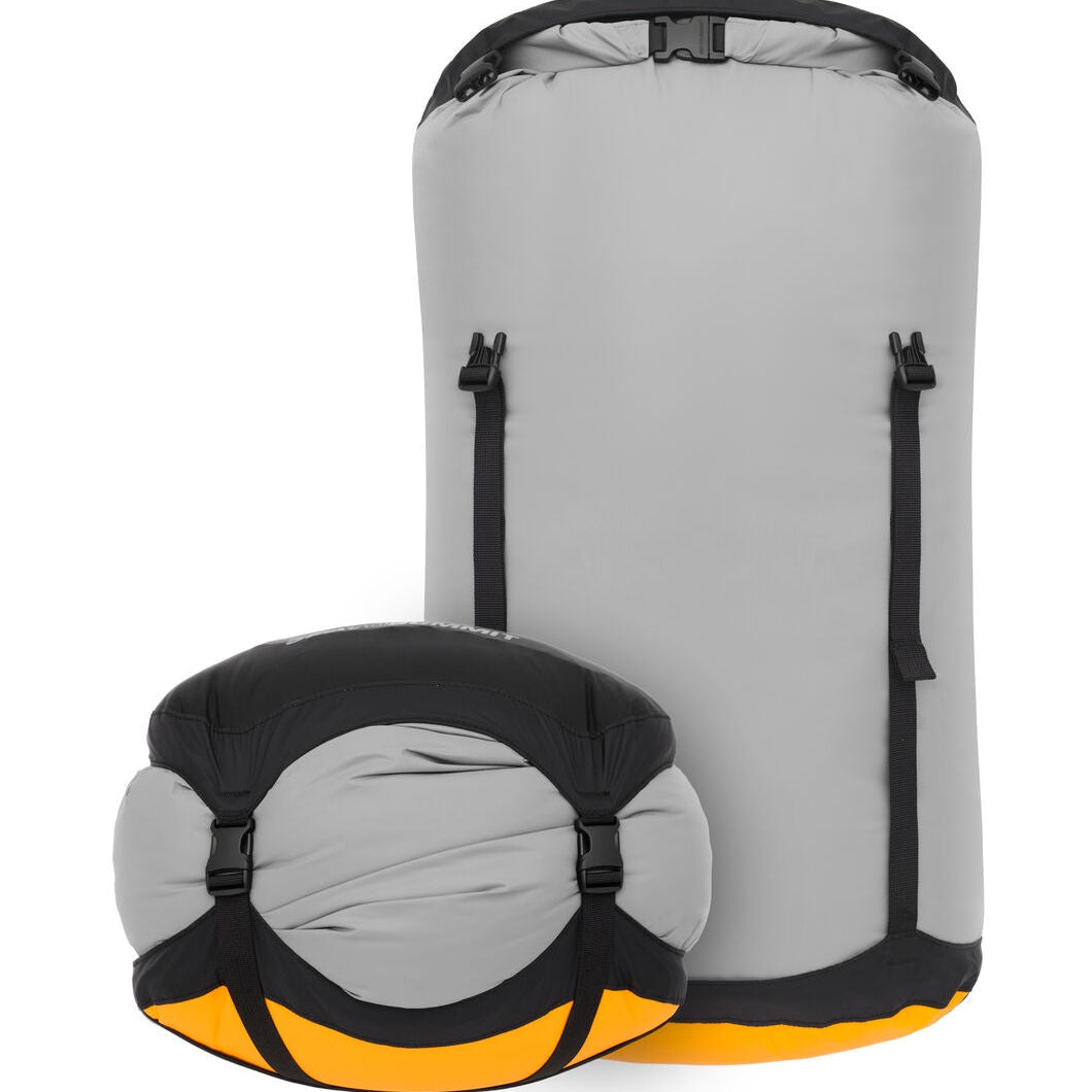 Gray compression sack with black webbing straps and yellow accents on a white background