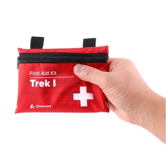 Red first aid kit labeled 'Trek I' held by a hand on a white background