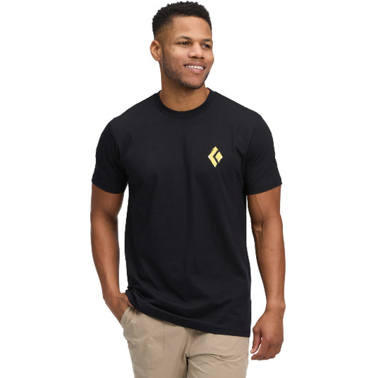 Man wearing a black t-shirt with a yellow logo on a white background