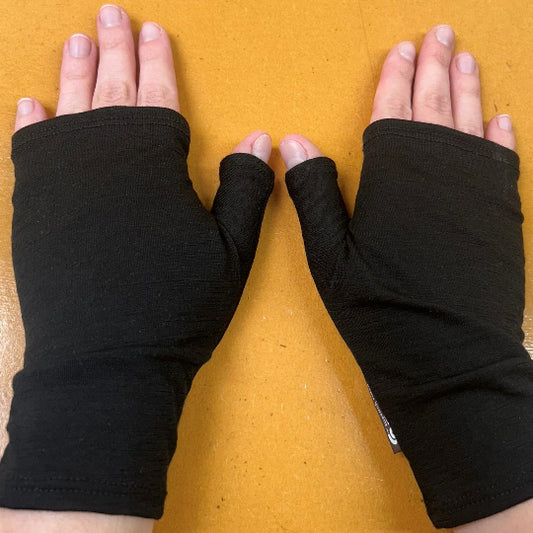 Black fingerless gloves on hands against a yellow background