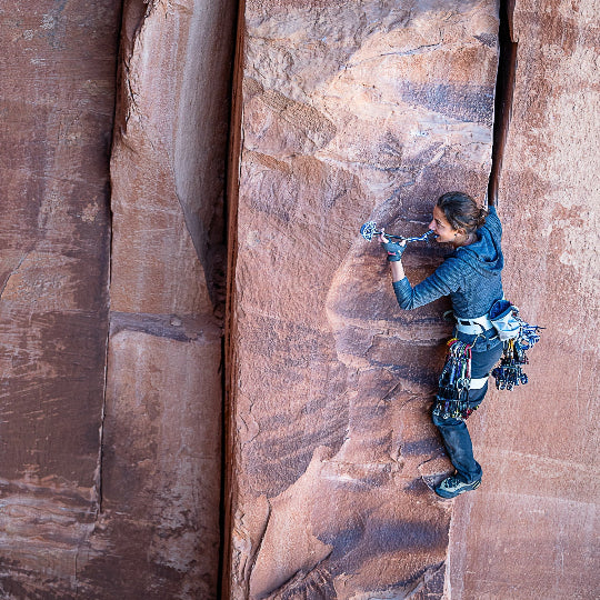 Person rock climbing on a large sandstone wall