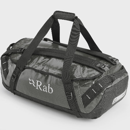 A grey and black heavy-duty kitbag with a brand logo 'rab' on the side, featuring a main opening, zippered closure, and multiple handles.