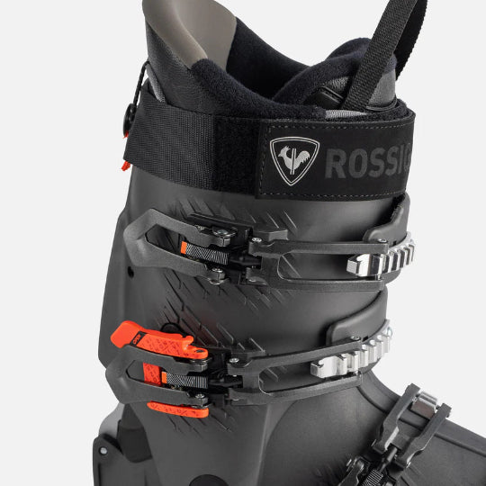 Close-up of a black ski boot with orange accents and Rossignol branding on a white background.