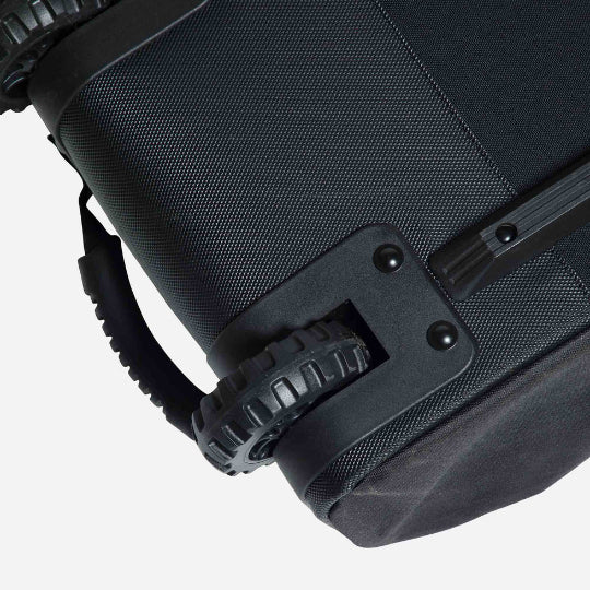 Close-up of a black suitcase with wheels on a white background
