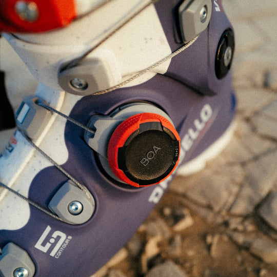 Close-up of a ski boot with BOA system on a stone surface