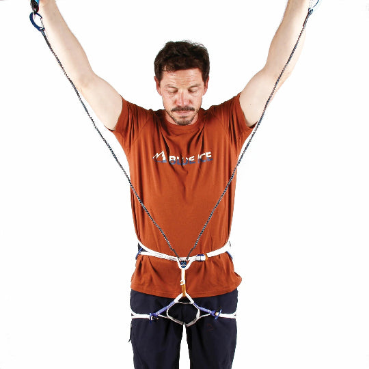Man wearing a climbing harness with leash attached on a white background