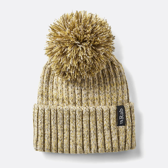 Beige knit beanie with pom-pom on a light gray background
