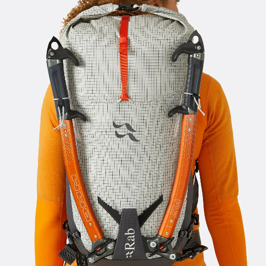 Person wearing a backpack with visible Rab branding on a white background