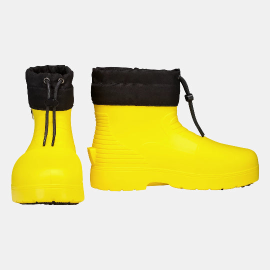 Pair of yellow rain boots with black cuffs on a light gray background