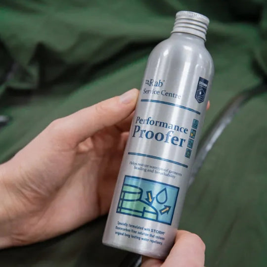 Person holding a can of 'Performance Proofer' against a green background