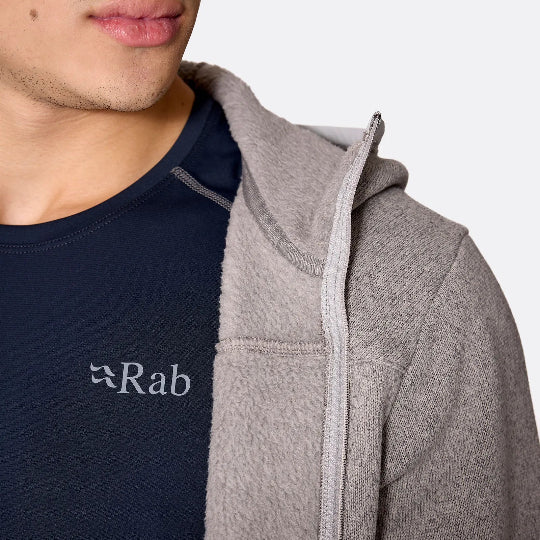 Person wearing a gray hoodie with a visible 'Rab' logo on a plain background