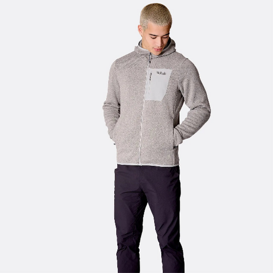 Person wearing a gray hoodie and dark pants on a white background