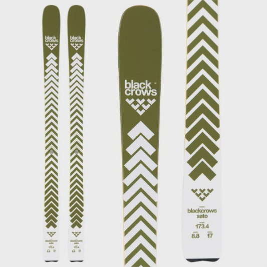 Green and white skis with blackcrows branding on a light gray background